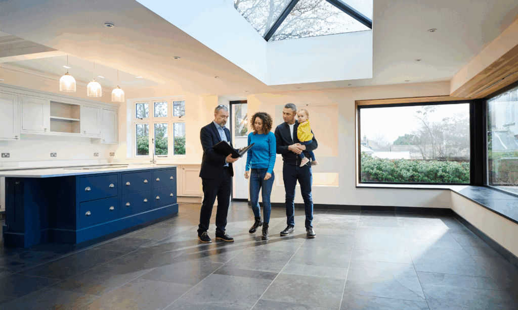Spacious open-plan living room with large sofas, natural light and a modern white kitchen.