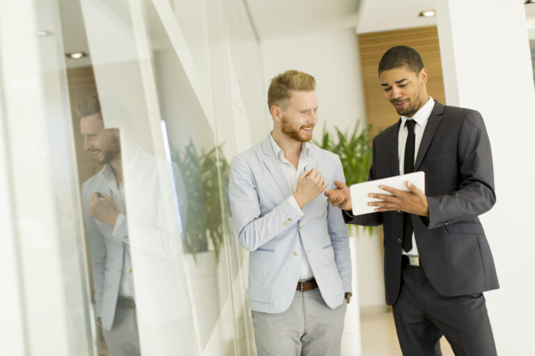 Two professionals reviewing property information on a tablet, representing landlord compliance, organisation and PRS database readiness