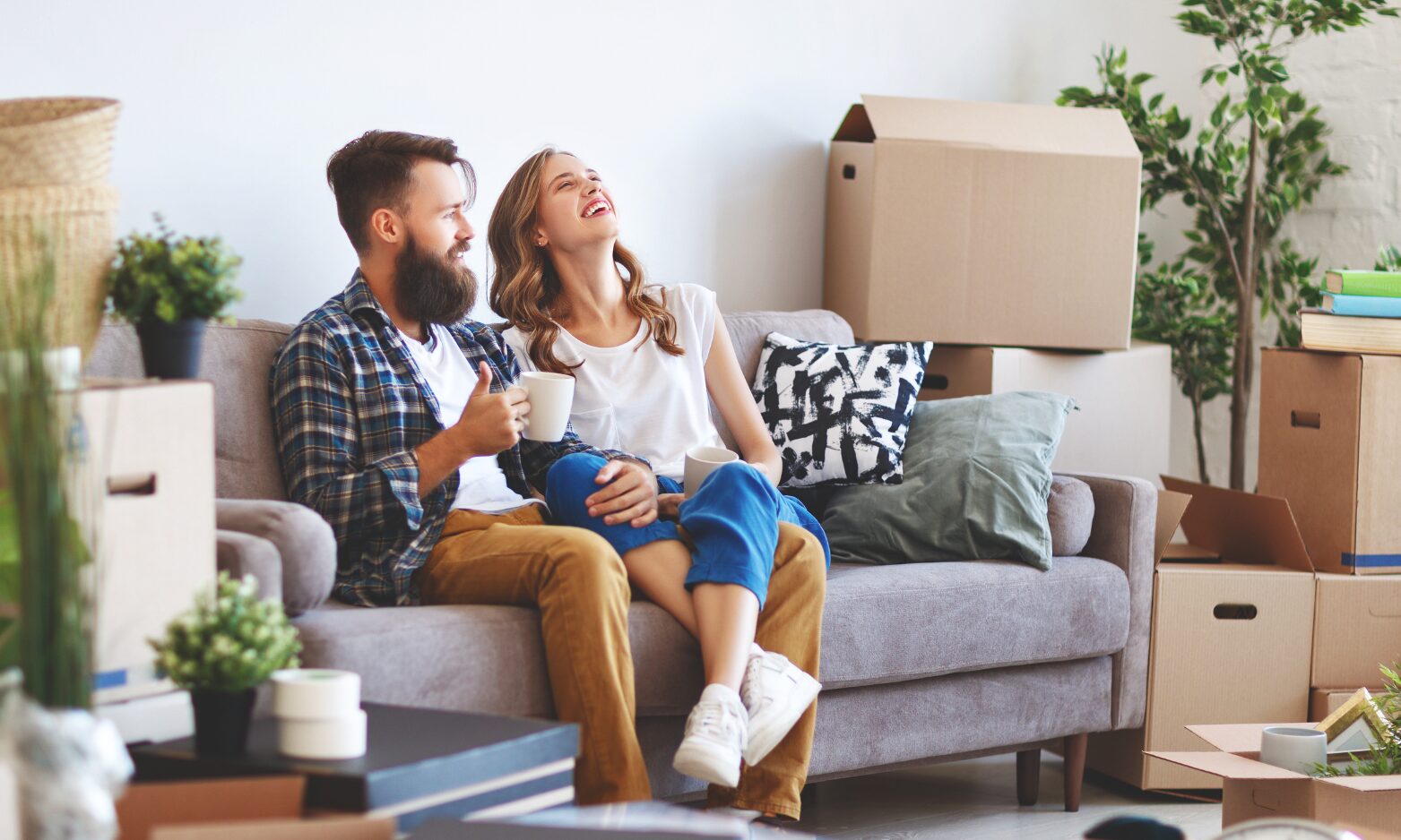 Couple relaxing in their new rental home surrounded by moving boxes, representing the lettings market in Sleaford and the surrounding area.