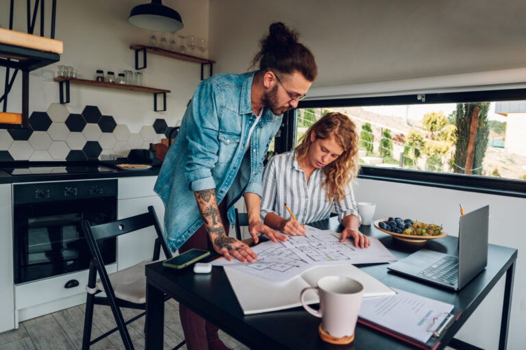 Couple reviewing property plans at home, representing sellers preparing to value and sell their Sleaford property.